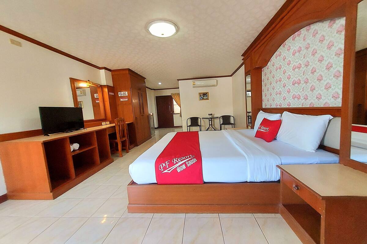 Une chambre d’hôtel avec un lit, une télévision, un bureau et une chaise.