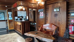 Un mostrador de recepción de madera con un cartel que dice "FINS HOTEL" y un letrero de prohibido fumar.