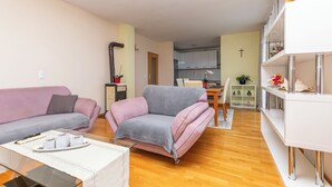 A living room with two sofas, a coffee table, and a white console table with decorative items. - Apartment Duce Beach (Duce)