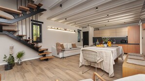 A modern interior with a staircase, a dining area, and a kitchen. - House Madonna di Smovo (Gata)