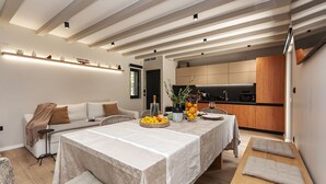 A modern living room with a dining area, a kitchen, and a cozy seating area. - House Madonna di Smovo (Gata)