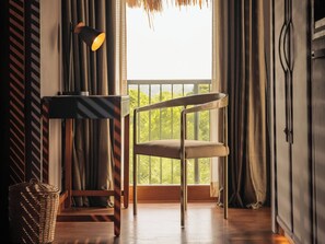 Enjoy the serene view of lush greenery from the comfort of this room, featuring a stylish chair and a cozy reading nook.