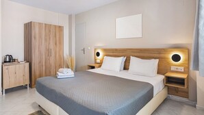Een moderne slaapkamer met een groot bed, een houten garderobe, nachtkastjes met lampen en een minimalistische inrichting.