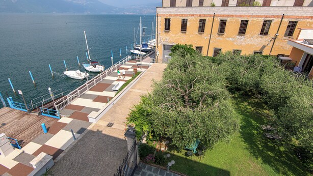 Ein Hotel direkt am Wasser mit Anlegesteg, Booten und einem Garten.
