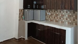 Una cocina moderna con armarios de madera oscura, un salpicadero de azulejos y una encimera blanca.