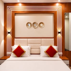 A neatly arranged bedroom with a bed, bedside tables, and wall-mounted light fixtures.