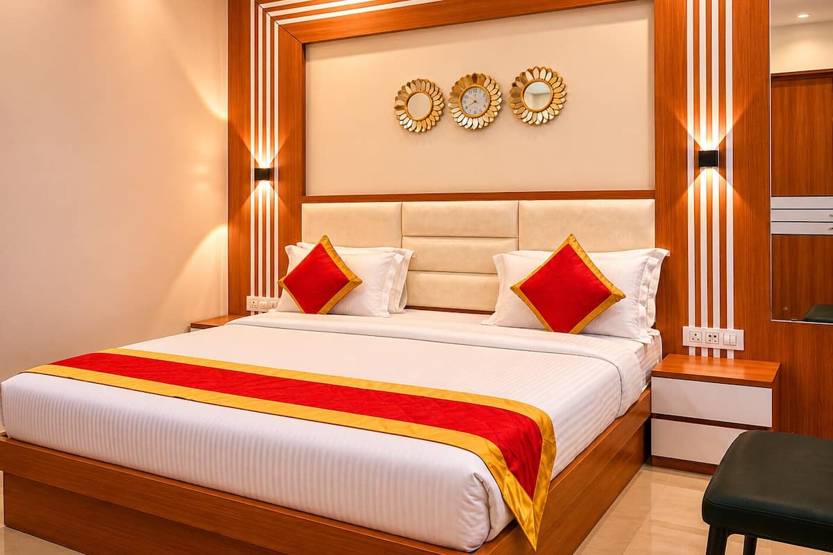 A modern hotel room with a large bed, a wooden headboard, wall-mounted clocks, and a bedside table.