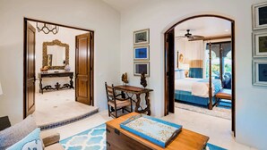 Una habitación con cama, escritorio, silla, espejo y ventilador de techo.