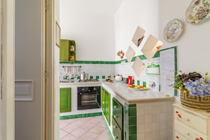 A kitchen with green cabinets, a stove, and a sink.