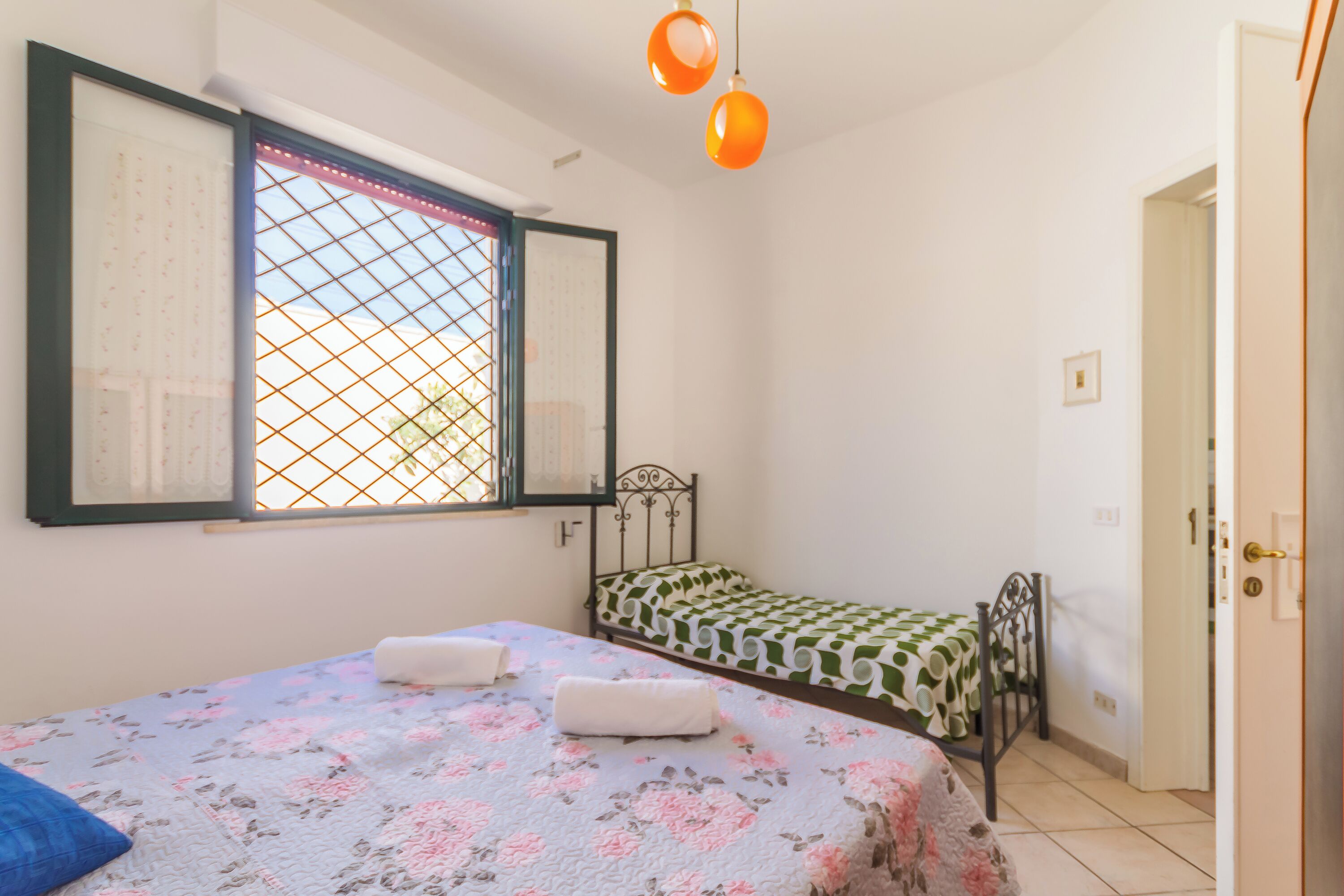 Une chambre avec deux lits, une fenêtre donnant sur un beau paysage et une porte.