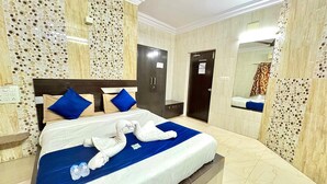 Ein Hotelzimmer mit Bett, Schrank, Spiegel und Badezimmer.