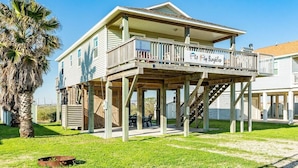 A two-story building with a balcony and a covered area, possibly a restaurant or cafe, with outdoor seating.