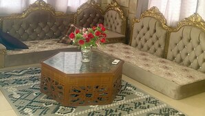 A living room with a tufted sofa, a round coffee table, and a patterned rug. - OYO 157 Dream Barka Hotel (Barka)