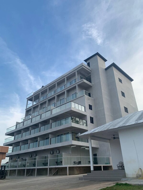 Un edificio de varios pisos con un diseño arquitectónico moderno, con balcones y ventanas amplias.