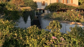 A two-story house with a small front garden, a visible staircase, and a satellite dish. - CASALE ARTEMISIA (Capalbio)