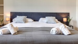 A neatly made bed with white linens and two rolled towels on the bed. - Colombo 76 in Firenze (Florence)