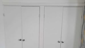 A room with two white wardrobes, a grey carpet, and a patterned wall. - Impeccable 4-bed House in Leicester (Leicester)