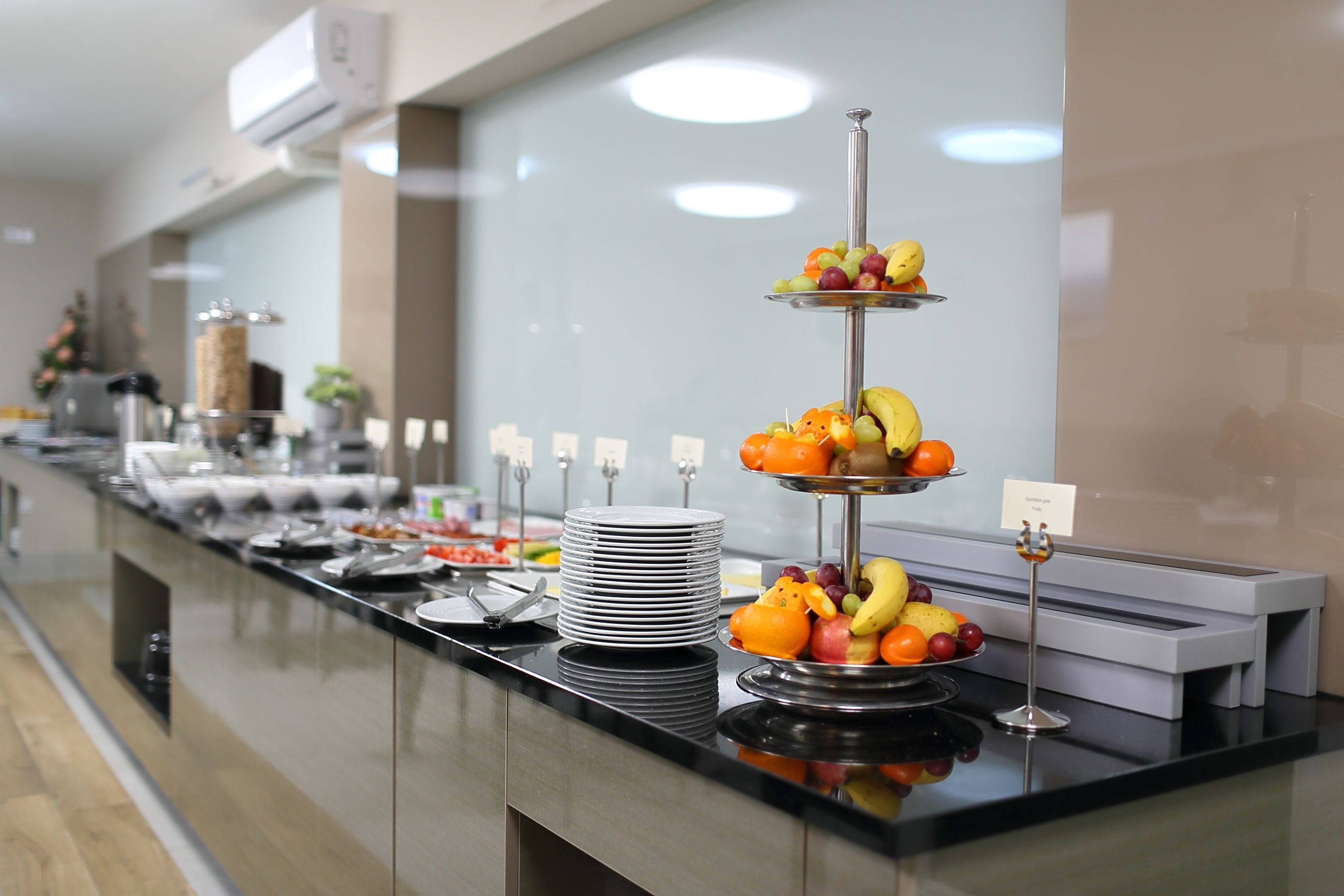 A buffet setup with various food items and a fruit display.