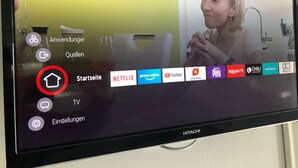 Una pantalla de televisor mostrando una interfaz de usuario con opciones como 'Anwendung', 'Quellen', 'Startseite', 'TV' y 'Einstellungen'.