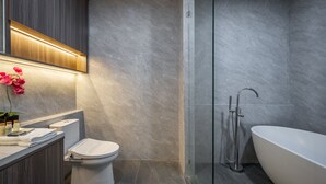 Une salle de bain moderne équipée de toilettes, d’un lavabo et d’une baignoire.