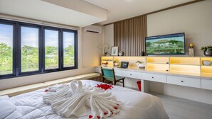 Une chambre d’hôtel moderne avec un grand lit, un bureau et une télévision.