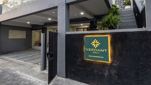 Un bâtiment moderne doté d’une façade en verre, d’un escalier et d’une enseigne indiquant « VERDANT – Bali ».