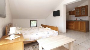 A bedroom with a bed, bedside table, lamp, and a small window. - Holiday apartment with air conditioning (Banjole)