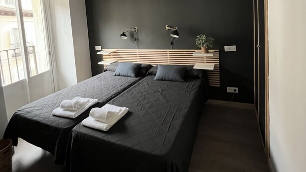 Une chambre moderne avec un grand lit, des lampes de chevet et un luminaire au plafond.