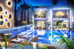 Ein modernes Hotel mit Pool, Außenbereich und einer gut beleuchteten Eingangshalle.