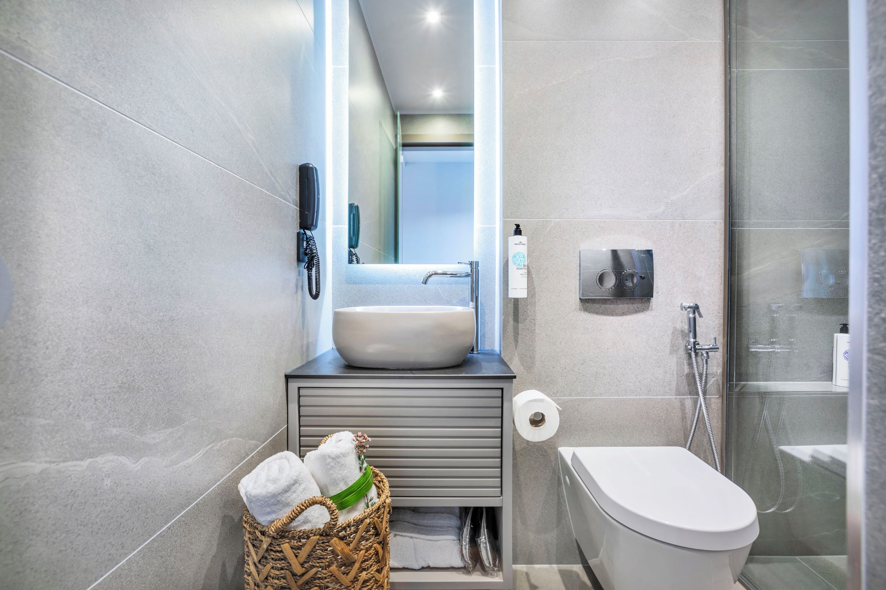 A modern bathroom with a large sink, toilet, and shower.