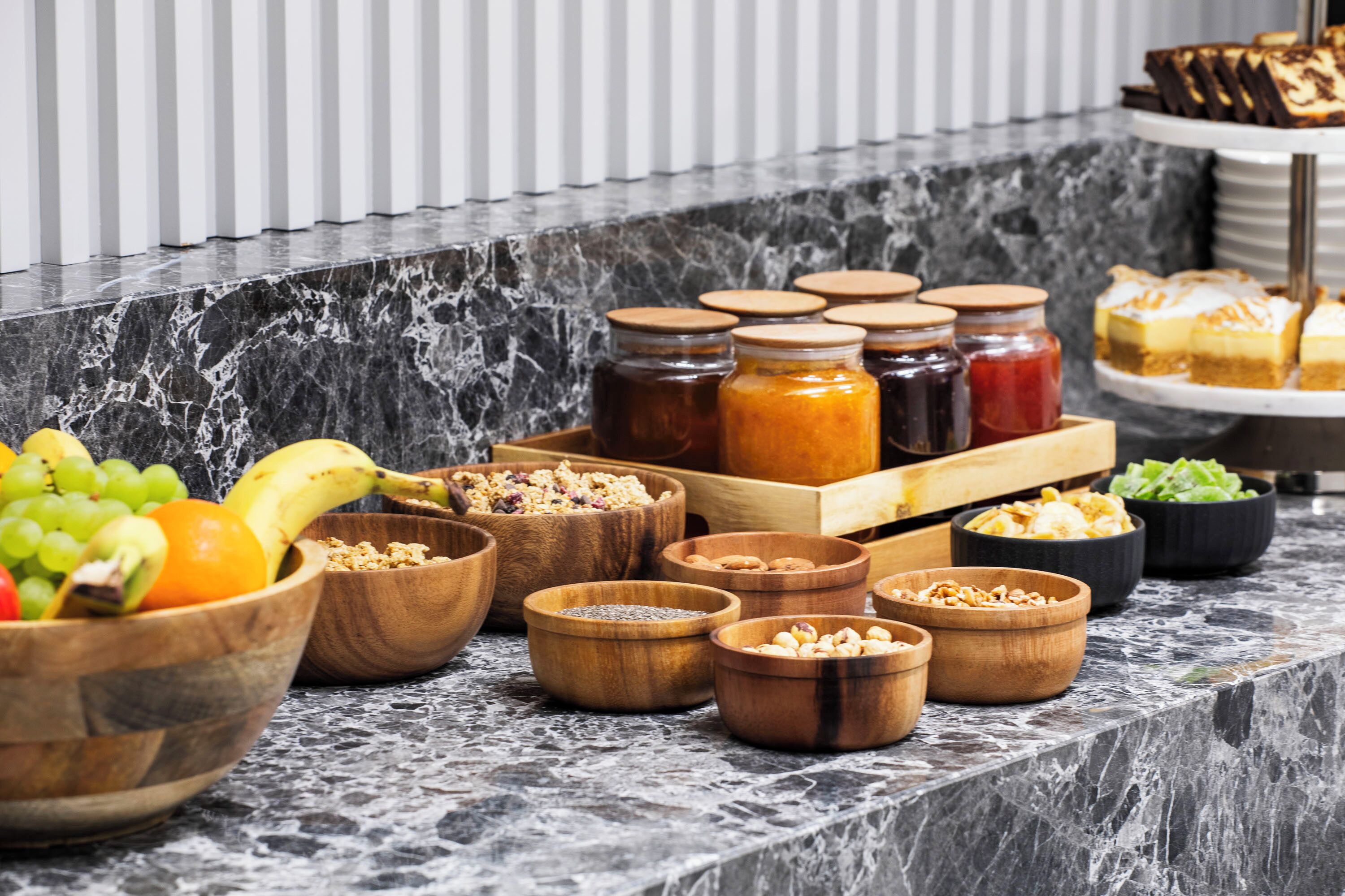 A buffet table with various food items and condiments.