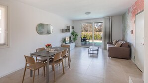 Un espace de vie moderne comprenant un coin repas, un canapé et une grande fenêtre.