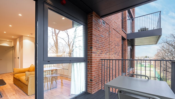 A modern apartment with a balcony, large windows, and a dining area. - Contemporary North London Flat (London)