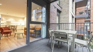 Un apartamento moderno con balcón, zona de comedor y cocina.