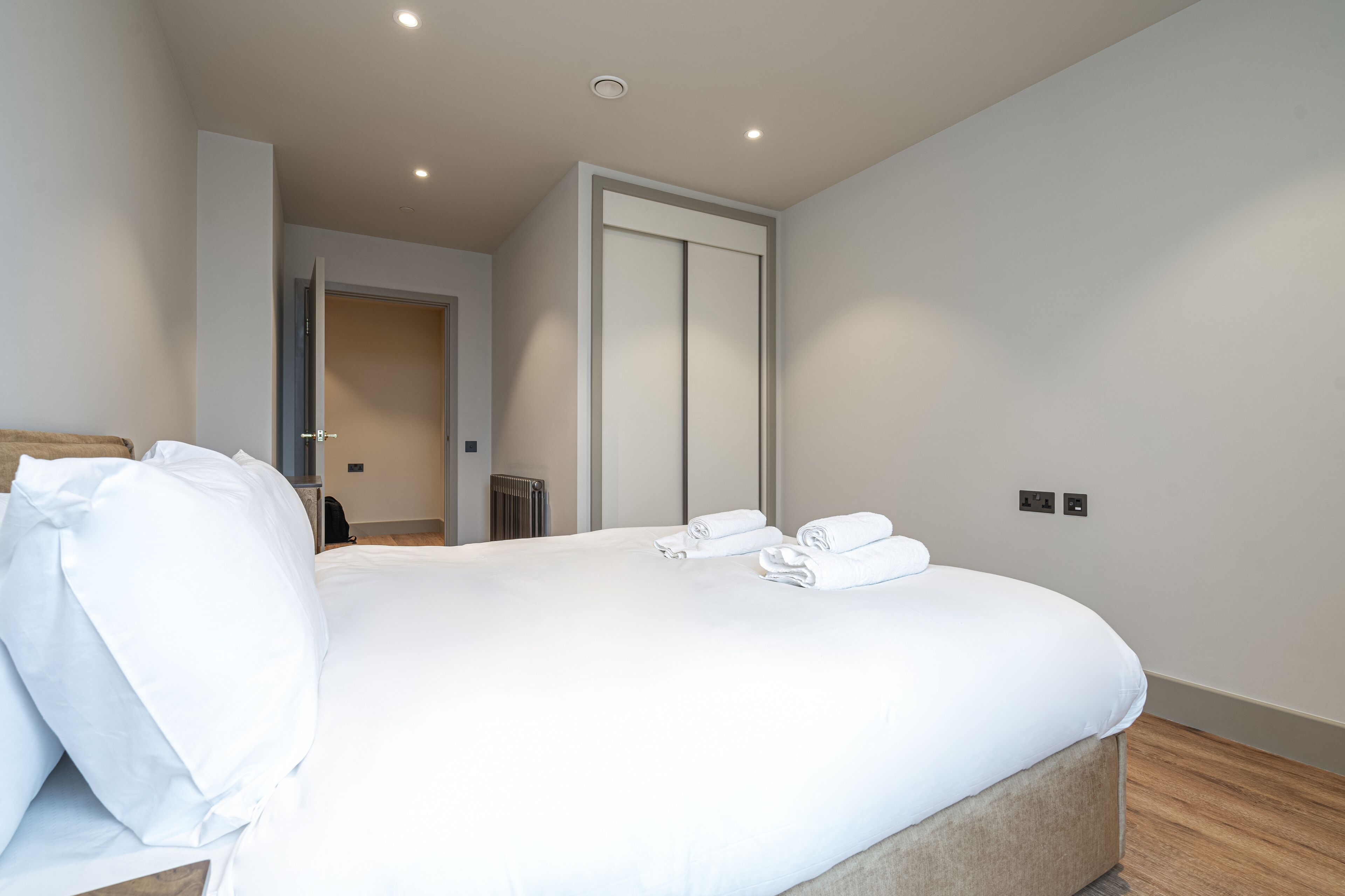 Een moderne hotelkamer met een groot bed, een kledingkast en een radiator.