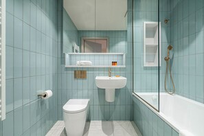 A bathroom with a toilet, sink, and bathtub.