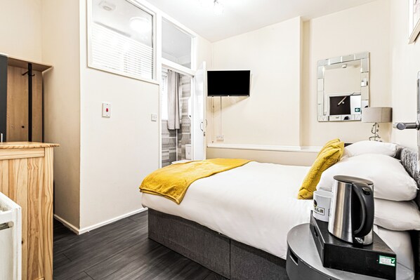 A hotel room with a bed, a television, a mirror, a coffee maker, and a wardrobe. - The B & B Blackpool (Blackpool)