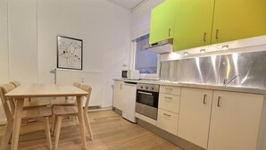 A modern kitchen with a dining table, a microwave, and a stove. - Li Tore 1 - Nice practical studio in the center (Liège)
