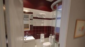 Ein Badezimmer mit einem weißen Waschbecken, einer Toilette und einer Duschfläche.