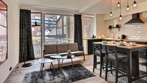 Une cuisine moderne avec un coin repas, de grandes fenêtres et un balcon.