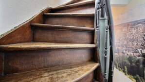 Una scala in legno con ringhiera metallica, che conduce a una vista sulla città.