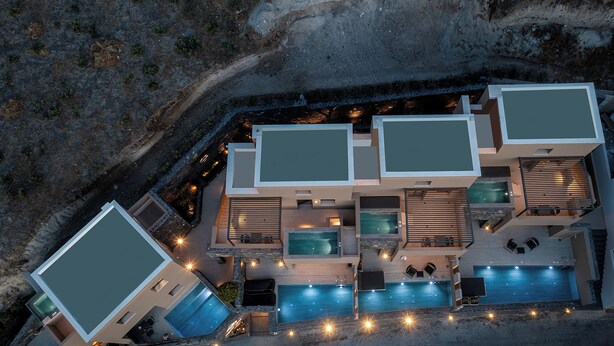 A modern, multi-level residential building with multiple swimming pools and outdoor seating areas. - Hidden Hills (Santorini)