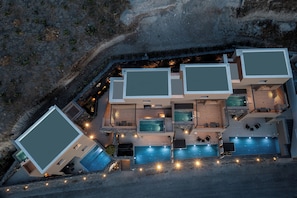 Un immeuble résidentiel moderne à plusieurs niveaux, doté de nombreuses piscines et d’espaces de détente en plein air.
