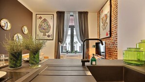 Una cocina moderna con un lavamanos grande, plantas en macetas y espejos decorativos.