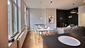 Un espace de vie moderne comprenant un coin repas, un canapé et un téléviseur.