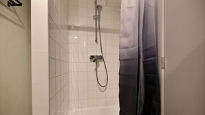 A bathroom with a shower, tiled walls, and a curtain. - Le Studio 15 - Superb Studio in the city center (Liège)