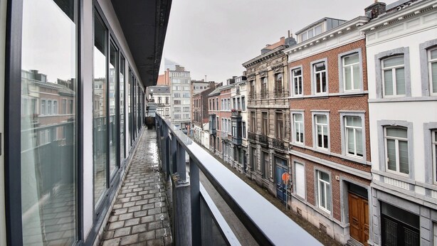 A narrow balcony with a view of traditional brick buildings and a modern glass building. - Rue des Ixellois - 2 bedrooms (Liège)
