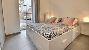 Een slaapkamer met een bed, een raam en een radiator.