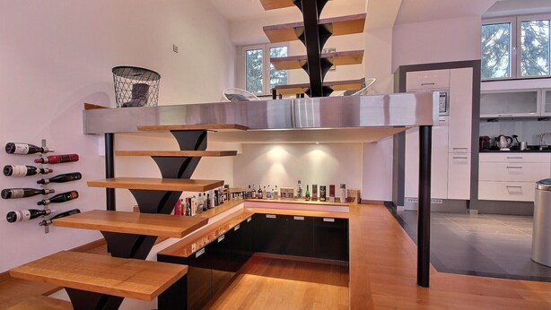 Una cocina moderna con mesas de madera y una estantería para vinos.