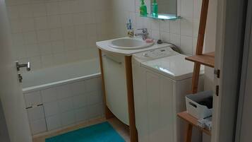 Een haardroger, handdoeken, zeep, toiletpapier